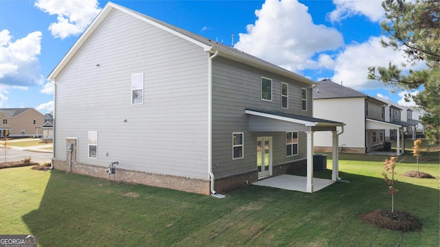 back of house with a lawn, cooling unit, and a patio