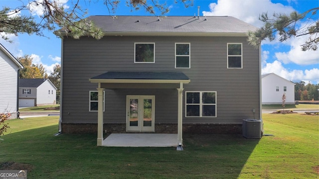 rear view of property featuring a yard, a patio, and central AC