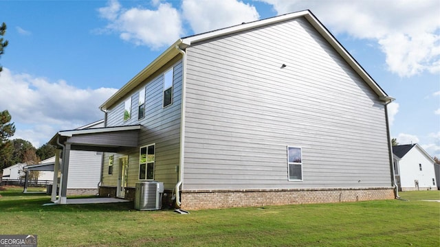 view of side of property with central AC and a lawn