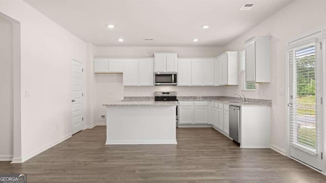 kitchen featuring a center island, white cabinets, sink, appliances with stainless steel finishes, and light stone counters