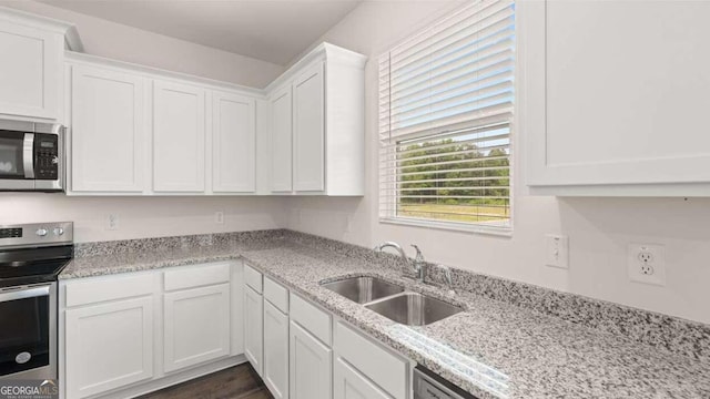 kitchen featuring light stone counters, white cabinetry, sink, and appliances with stainless steel finishes