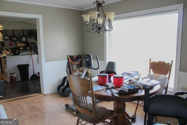 dining space featuring crown molding, a notable chandelier, and light wood-type flooring