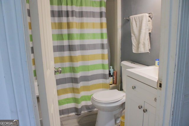 bathroom featuring toilet, vanity, and a shower with shower curtain