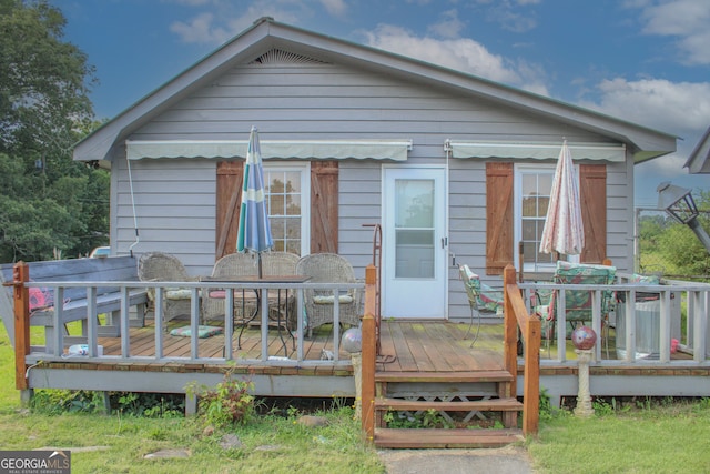 rear view of property featuring a wooden deck