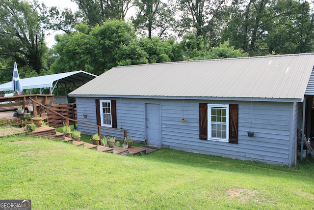 back of property featuring a carport and a yard