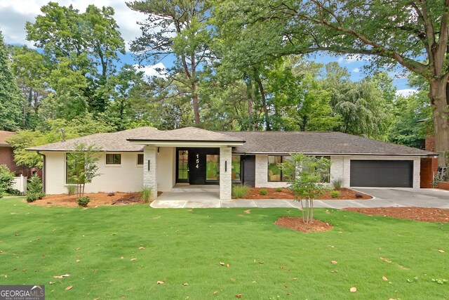 view of front of property featuring a garage and a front lawn