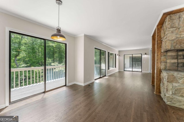 unfurnished living room featuring crown molding and dark wood-type flooring