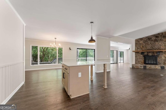 kitchen with a center island, decorative light fixtures, a wealth of natural light, and dark hardwood / wood-style floors