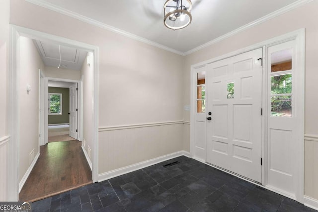 tiled foyer featuring a wealth of natural light and ornamental molding