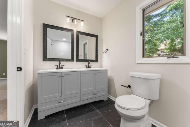 bathroom featuring tile flooring, double vanity, and toilet