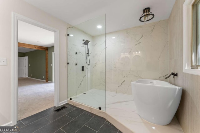 bathroom featuring tile flooring, a shower with shower door, and tile walls