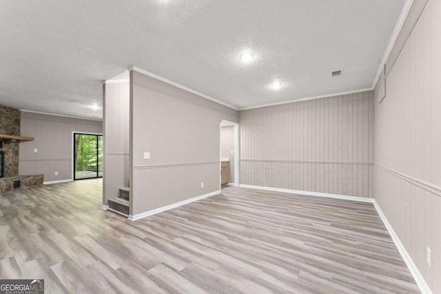 interior space featuring a textured ceiling, a fireplace, and light wood-type flooring