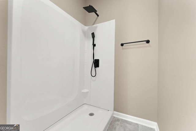 bathroom with tile flooring and a shower