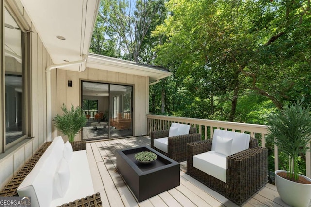 wooden deck with an outdoor living space with a fire pit