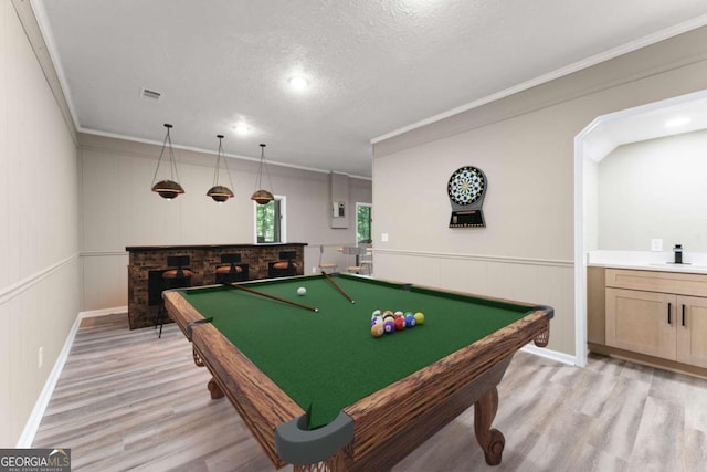 playroom with billiards, light hardwood / wood-style flooring, a textured ceiling, and ornamental molding