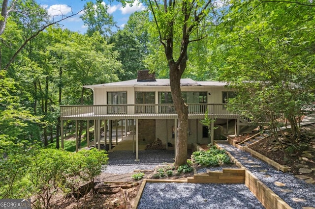 back of house with a deck and a patio area