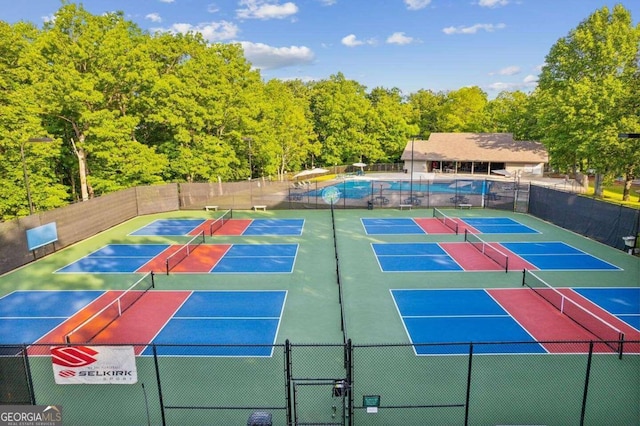 view of tennis court featuring a fenced in pool