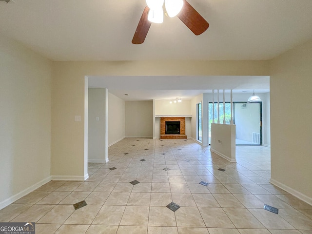 unfurnished living room featuring ceiling fan, light tile patterned flooring, and a brick fireplace