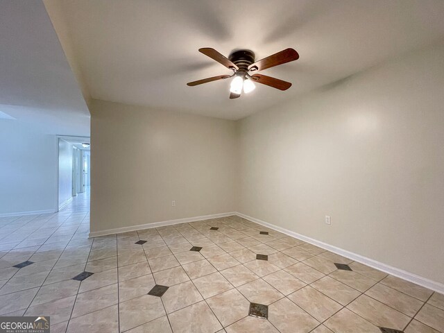 empty room with ceiling fan and light tile patterned floors