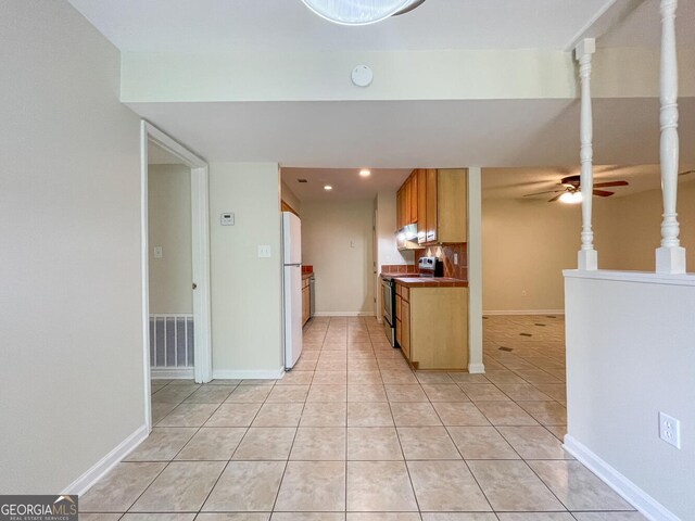 kitchen with electric range, ceiling fan, white refrigerator, and light tile patterned floors