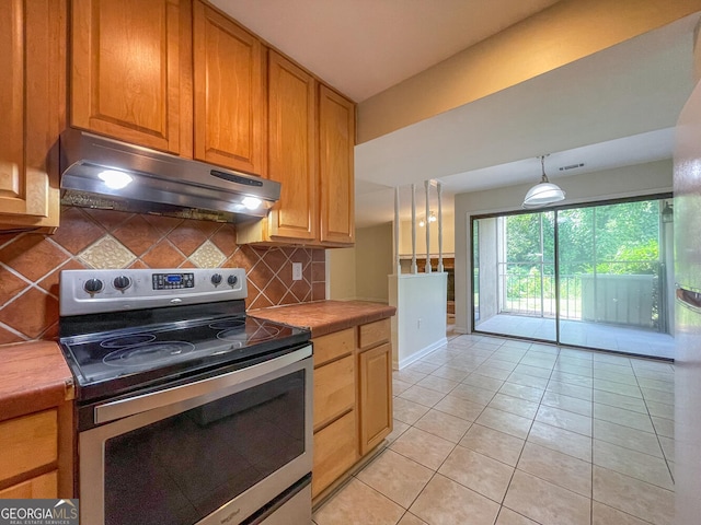 kitchen featuring tasteful backsplash, light tile patterned floors, pendant lighting, and stainless steel electric range