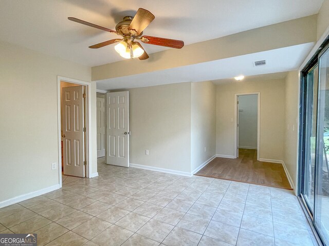 tiled spare room with ceiling fan