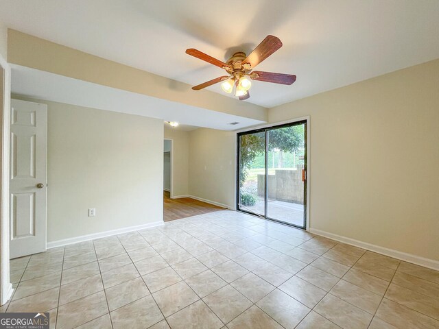 empty room with ceiling fan and light tile patterned flooring