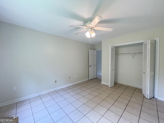 unfurnished bedroom with light tile patterned floors, a closet, and ceiling fan