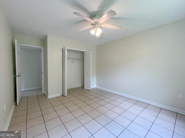 unfurnished bedroom featuring light tile patterned floors, a closet, and ceiling fan