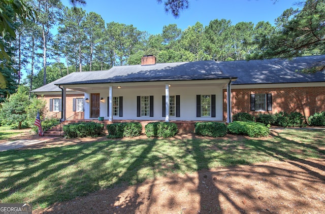 ranch-style house featuring a front lawn and covered porch