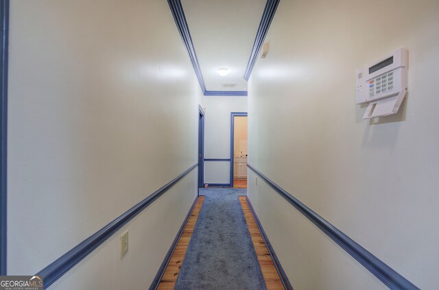 hall featuring ornamental molding and dark hardwood / wood-style flooring