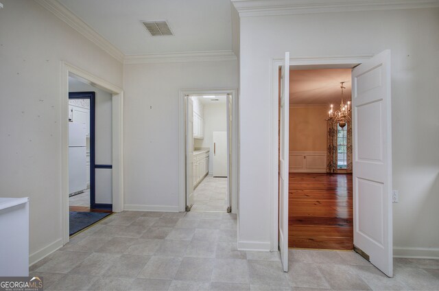 hallway featuring crown molding, a notable chandelier, and light wood-type flooring