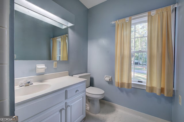 bathroom featuring toilet, vanity, and tile patterned flooring