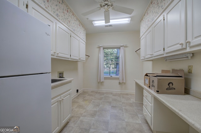 laundry area with ceiling fan, washer hookup, and cabinets