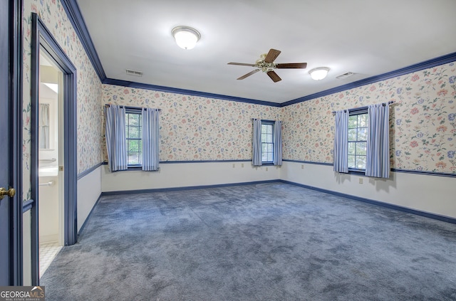 empty room featuring ornamental molding, dark carpet, and ceiling fan