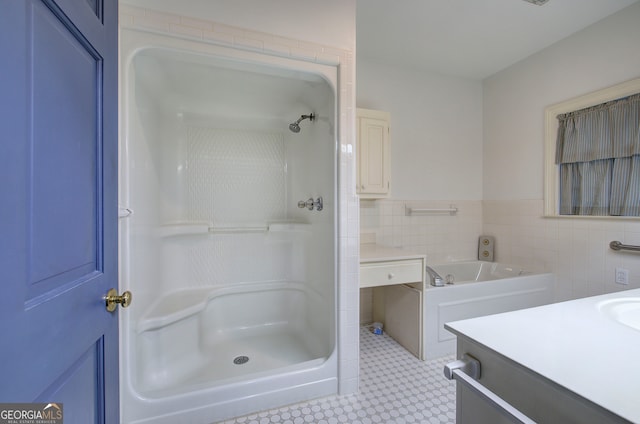 bathroom featuring vanity, tile walls, and plus walk in shower