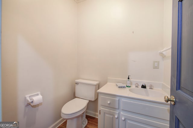 bathroom with vanity, toilet, and hardwood / wood-style flooring