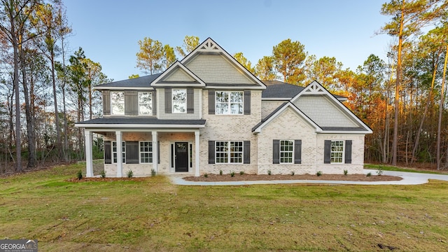 craftsman inspired home featuring a front lawn and covered porch