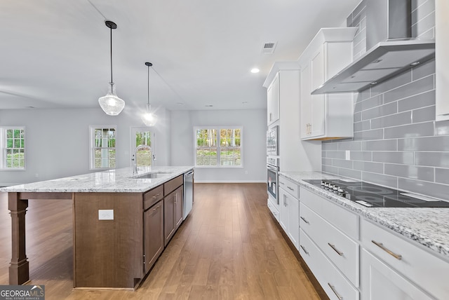 kitchen featuring stainless steel appliances, white cabinetry, wall chimney exhaust hood, and sink