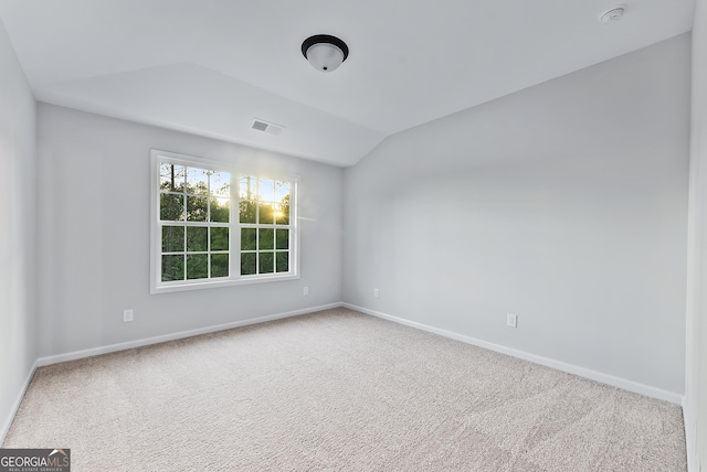 unfurnished room featuring lofted ceiling and carpet floors