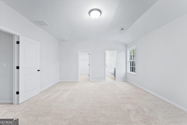 carpeted empty room with lofted ceiling