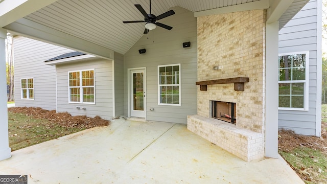 view of patio featuring an outdoor brick fireplace and ceiling fan