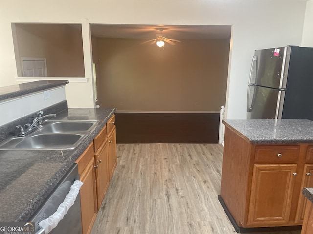 kitchen with ceiling fan, sink, appliances with stainless steel finishes, and light hardwood / wood-style flooring