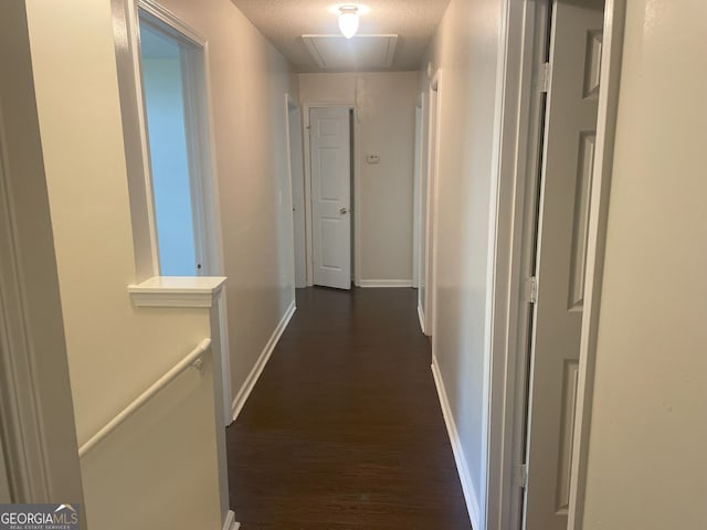 corridor featuring dark hardwood / wood-style flooring and a textured ceiling