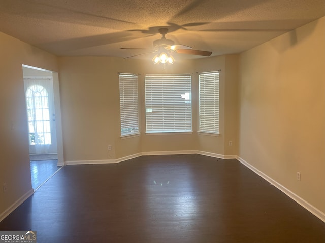 unfurnished room featuring ceiling fan, dark wood-type flooring, and a textured ceiling