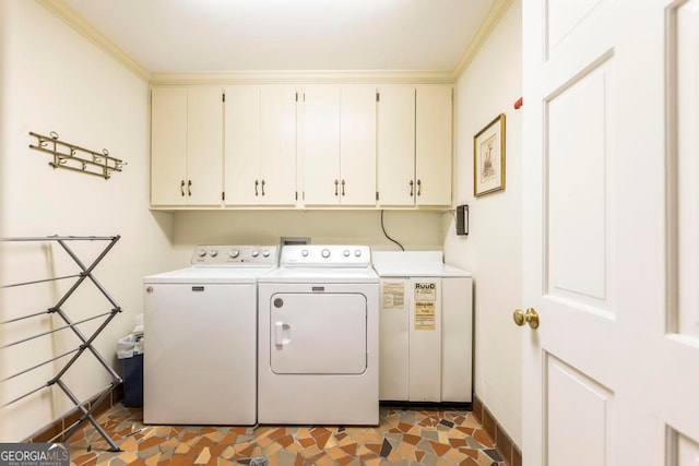 clothes washing area featuring separate washer and dryer, cabinets, crown molding, and dark tile patterned floors