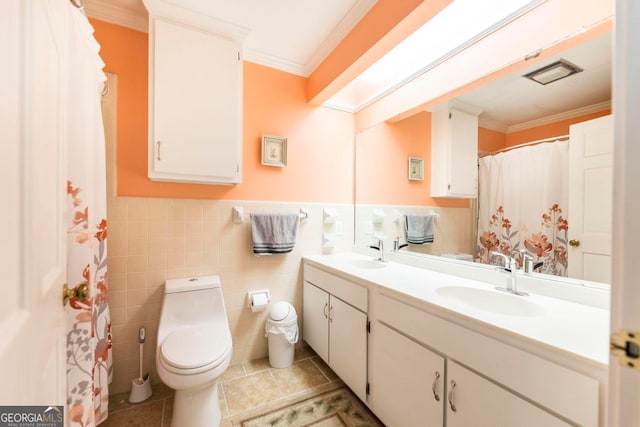 bathroom with vanity, tile patterned floors, tile walls, crown molding, and toilet