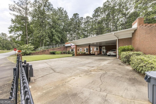 101 Huntington Dr, Dublin, GA 31021 - view of parking / parking lot featuring a carport, driveway, and view of wooded area