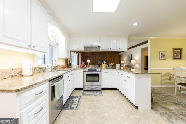101 Huntington Dr, Dublin, GA 31021 - kitchen with light tile patterned floors, ornamental molding, a peninsula, under cabinet range hood, and stainless steel appliances