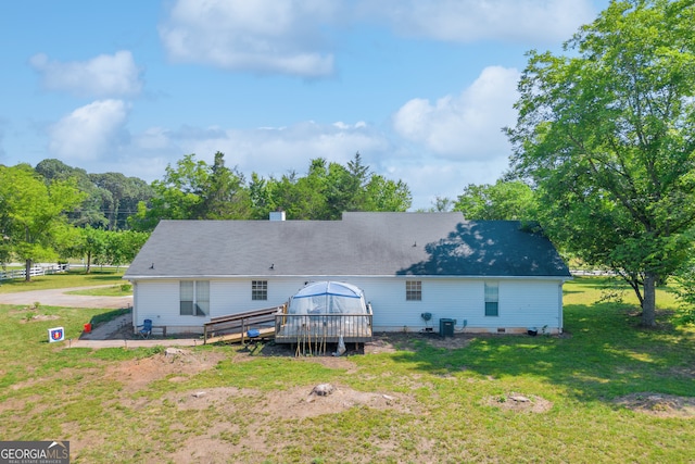 back of property featuring a wooden deck, a yard, and cooling unit